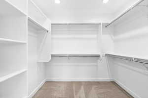 Walk in closet with light carpet