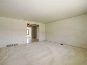 Carpeted spare room with crown molding and ceiling fan