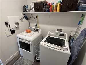 Laundry room with hardwood / wood-style flooring, hookup for a washing machine, and washing machine and dryer