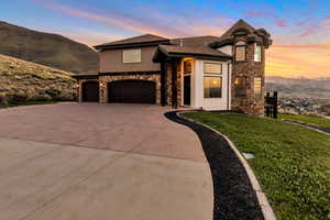 View of front of home with a mountain view, a yard, and a garage