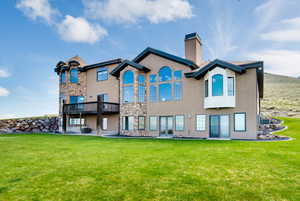 Rear view of property featuring central air condition unit and a lawn