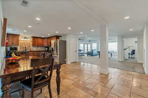 Dining room with sink, ceiling fan, and light tile floors