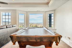 Recreation room with a tray ceiling, crown molding, carpet floors, and billiards