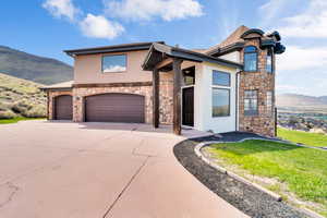 View of front of home with a garage, a mountain view, and a front yard