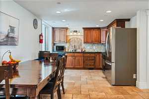Kitchen with appliances with stainless steel finishes, sink, tasteful backsplash, and light tile flooring