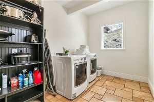 Laundry area with washer and dryer and light tile floors