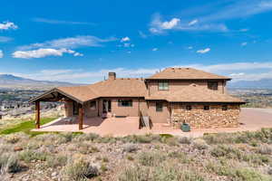 Back of house featuring a mountain view, central AC unit, and a patio