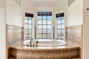 Bathroom with tile walls and tiled bath