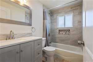 Full bathroom with shower / bath combo with shower curtain, toilet, vanity, and wood-type flooring