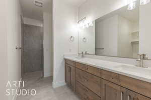 Bathroom featuring tile patterned floors, vanity, and walk in shower