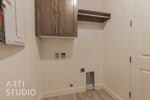 Laundry area featuring cabinets, washer hookup, light hardwood / wood-style flooring, and hookup for an electric dryer