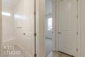 Corridor featuring a healthy amount of sunlight and light hardwood / wood-style floors