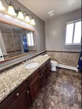 Bathroom featuring tile floors, vanity, and toilet