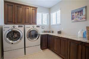 Clothes washing area with cabinets and washer and dryer
