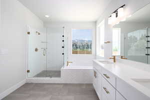 Bathroom with tile flooring, shower with separate bathtub, and double vanity