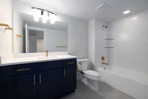 Full bathroom featuring tiled shower / bath combo, vanity, toilet, and tile floors