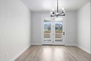 Unfurnished dining area with a notable chandelier and light wood-type flooring