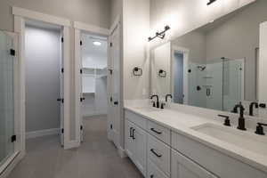 Bathroom with double sink vanity, tile floors, and walk in shower