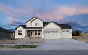 View of front of home with covered porch and a garage