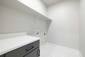 Clothes washing area featuring hookup for a washing machine, hookup for an electric dryer, and light tile floors