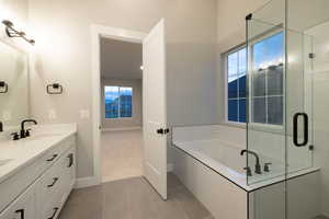 Bathroom featuring a healthy amount of sunlight, tile flooring, oversized vanity, and dual sinks