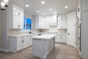 Kitchen featuring appliances with stainless steel finishes, light hardwood / wood-style floors, and tasteful backsplash