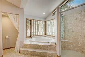 Bathroom featuring lofted ceiling, tile floors, and plus walk in shower