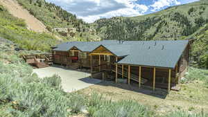 Back of property with central AC unit and a deck with mountain view