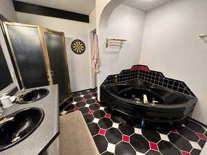 Bathroom featuring tile flooring, double vanity, and separate shower and tub