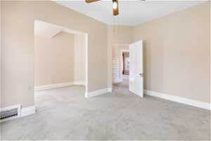 Unfurnished bedroom featuring ceiling fan and carpet