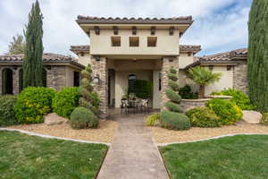 Mediterranean / spanish home with a front yard and a patio area