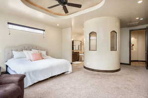 Bedroom with ceiling fan, connected bathroom, and carpet flooring