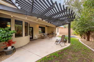 View of terrace with ceiling fan and a pergola