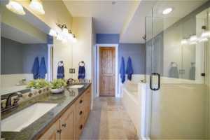 Bathroom with dual sinks, tile floors, independent shower and bath, and large vanity