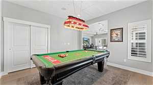Recreation room with wood-type flooring and pool table