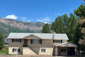 View of front of home with a mountain view and a carport