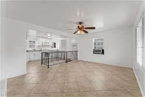 Empty room featuring sink, ceiling fan, and light tile floors