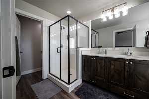 Master Bathroom featuring walk in shower, hardwood / wood-style flooring, and dual sinks