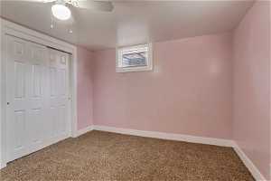 Unfurnished bedroom featuring carpet, ceiling fan, and a closet