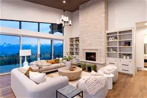 Living room featuring light hardwood / wood-style floors, a mountain view, a towering ceiling, and a fireplace