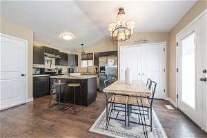 Kitchen featuring lofted ceiling, a center island, stainless steel appliances, and dark hardwood / wood-style floors