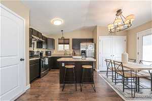 Kitchen featuring a wealth of natural light, stainless steel appliances, dark hardwood / wood-style floors, and a kitchen island