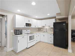 Basement Kitchen featuring light tile floors, white cabinets, white appliances, and sink