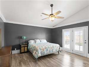 Master Bedroom with double doors out onto deck- ornamental molding, vaulted ceiling, hardwood / wood-style floors, and access to outside