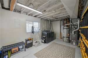 Basement featuring strapped water heater and independent washer and dryer