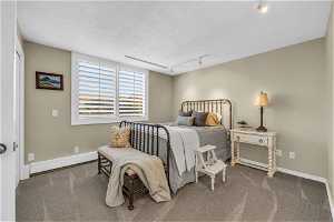 Bedroom featuring carpet, track lighting, a baseboard heating unit with an on-suite bathroom