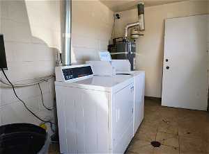 Common Washroom with water heater, Coin washer and dryer, and tile floors