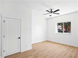 Empty room with ceiling fan and light hardwood / wood-style floors