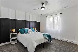 Bedroom featuring a textured ceiling, dark carpet, and ceiling fan