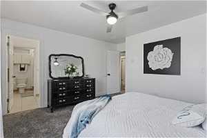 Bedroom with ensuite bath, carpet, and ceiling fan